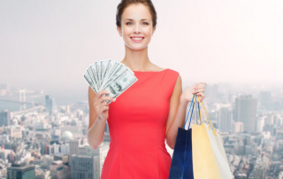 Frau im roten Kleid hält Geldscheine und Einkaufstüten in den Händen
