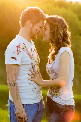 Romantisches Paar trägt mit Farbe beschmierte Shirts und grinst