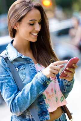 Frau schaut lächelnd aufs Smartphone