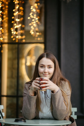 Frau mit Kaffeebecher hat intensiven Blickkontakt beim Date