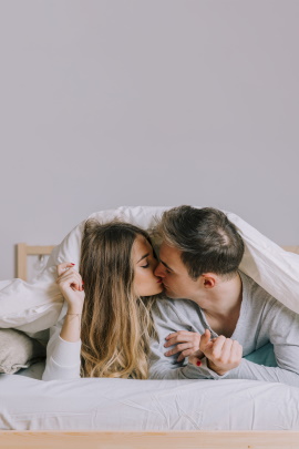 Mann und Frau im Bett küssen sich