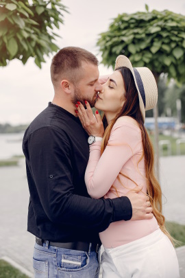 Verliebte Partner küssen sich im Sommer am See