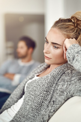 Frau und Mann sitzen gelangweilt auf dem Sofa