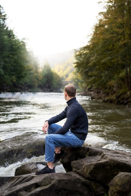 Mann schaut nachdenklich auf einen Fluss