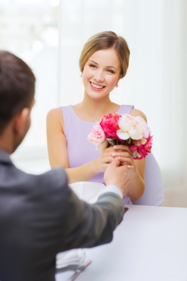 Glückliches Paar im Restaurant mit Blumen