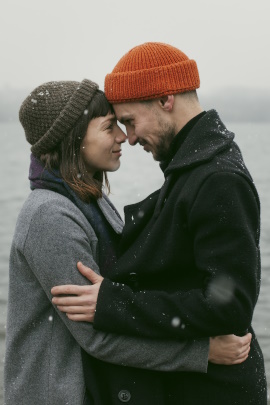 Verliebtes Paar umarmt sich mit intensivem Blickkontakt am See
