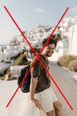 Mann im Urlaub steht lächelnd am Straßenrand