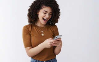 Frau freut sich über SMS von Mann, den sie erobern will