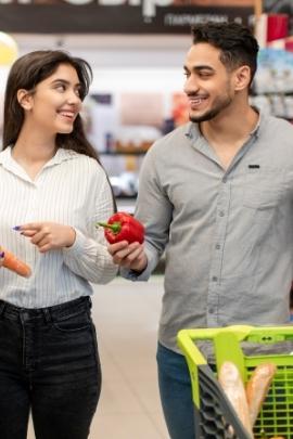 Frau spricht Mann im Supermarkt an