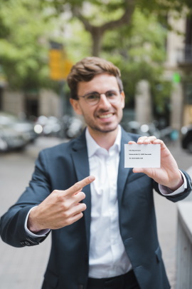 Business-Mann auf der Straße zeigt Visitenkarte