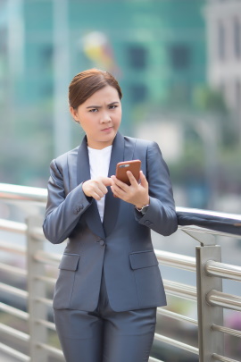 Verwunderte Frau auf Brücke mit Smartphone in der Hand