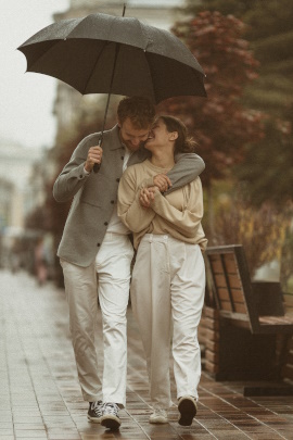 Paar unterm Regenschirm flirtet miteinander