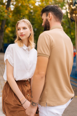 Mann hält genervt blickende Frau an den Händen