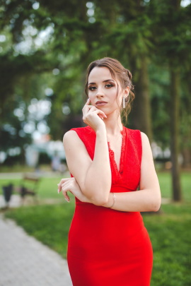 Attraktive Frau im roten Kleid steht im Park