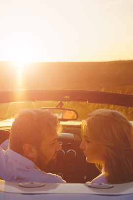 Verliebtes Paar im Auto fährt in den Sonnenaufgang