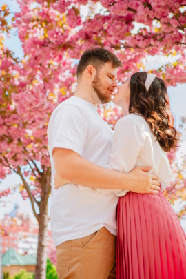 Mann und Frau umarmen sich vorm blühenden Kirschbaum