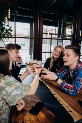 Zwei Pärchen sitzen fröhlich in der Kneipe und trinken Bier