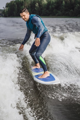 Mann steht im Wasser auf Surfbrett