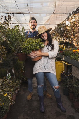 Paar steht im Gartencenter mit neu gekauften Pflanzen