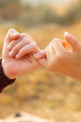 Frau und Mann geben sich Versprechen mit kleinem Finger