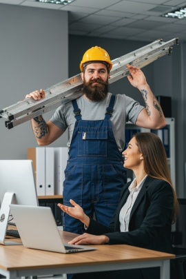 Handwerker steht im Büro und redet mit Sekretärin am Schreibtisch