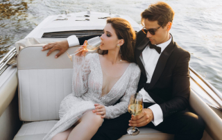 Reiche Frau und Mann sitzen im Boot und trinken Wein