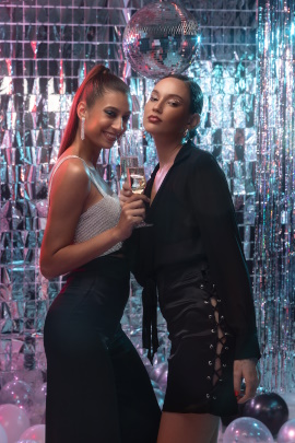 Zwei reiche Frauen mit Sektglas in der Disco