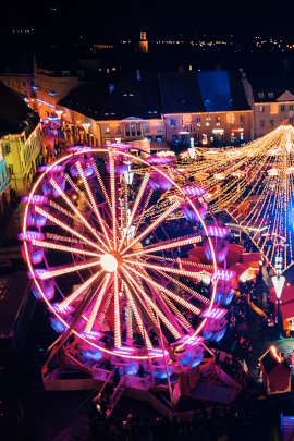 Beleuchtetes Riesenrad auf einem Weihnachtsmarkt von oben