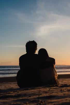 Mann und Frau sitzen romantisch am Strand