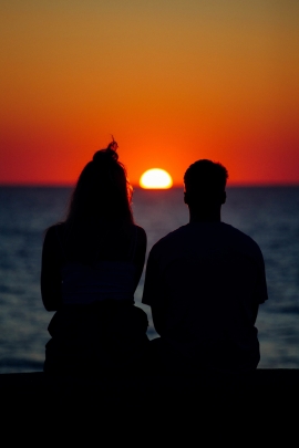 Mann und Frau schauen sich den Sonnenaufgang an