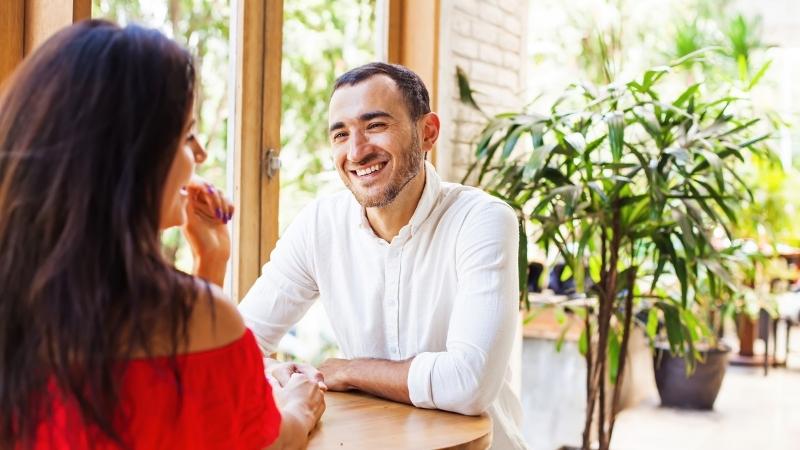 Mann lächelt Frau beim Speed-Dating an