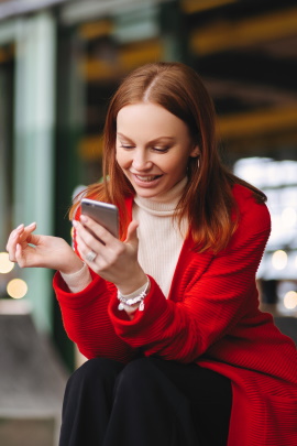 Frau schaut lächelnd aufs Handy