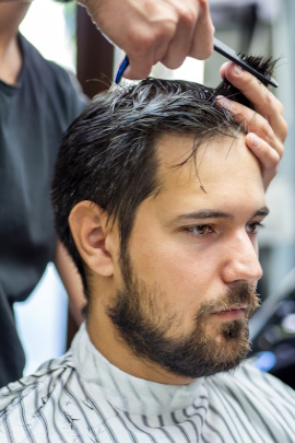 Mann mit Liebeskummer bekommt neuen Haarschnitt beim Friseur