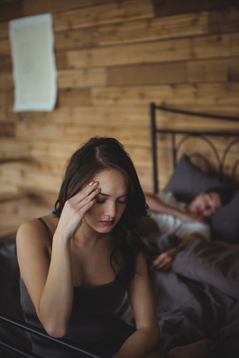 Geliebte des Mannes sitzt unglücklich auf dem Bett