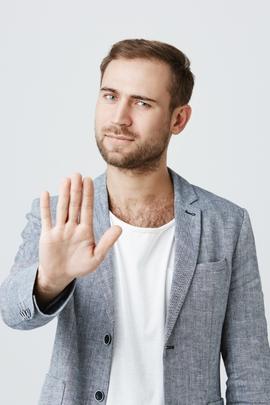 Mann hält Hand als Stopp-Zeichen vor