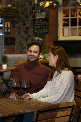 Paar sitzt abends im Außenbereich eines Restaurants