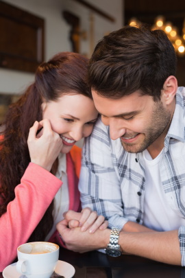 Verliebtes Paar beim Date im Café hält glücklich Händchen
