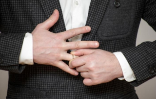 Mann zieht seinen Ehering vom Finger