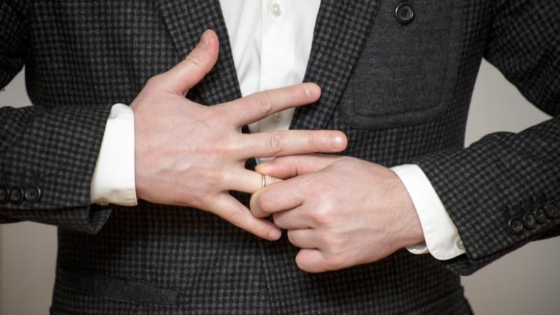 Mann zieht seinen Ehering vom Finger