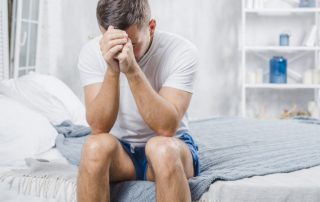 Unglücklicher Single-Mann sitzt auf dem Bett