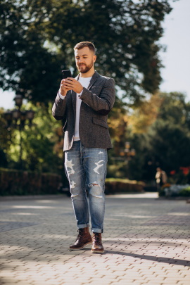 Attraktiver Mann liest Nachricht auf dem Smartphone