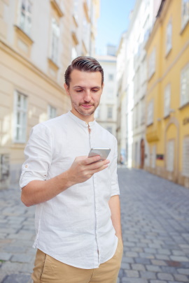 Mann in der Stadt liest Nachricht am Handy