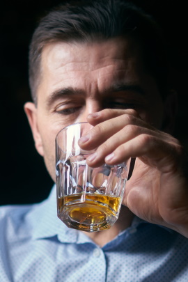 Mann trinkt ein Glas Whiskey