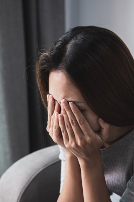 Ex-Freundin weint mit Händen vor dem Gesicht