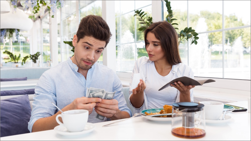 Paar sitzt im Restaurant und zählt Geld