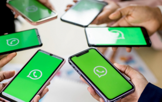 Menschen halten Smartphones mit WhatsApp-Logo im Display