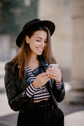 Single-Frau schaut auf ihr Handy und lächelt