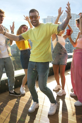 Mann tanzt auf einer Party auf dem Balkon