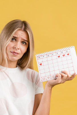 Frau mit sorgenvollem Blick hält Kalender in der Hand