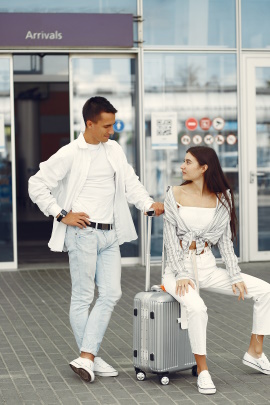 Paar mit Koffer wartet am Ausgang vom Flughafen